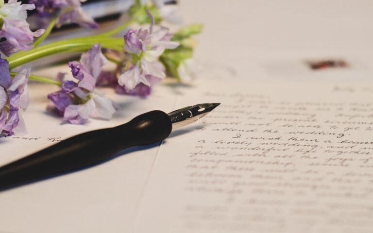 ink pen on paper with flowers in the background